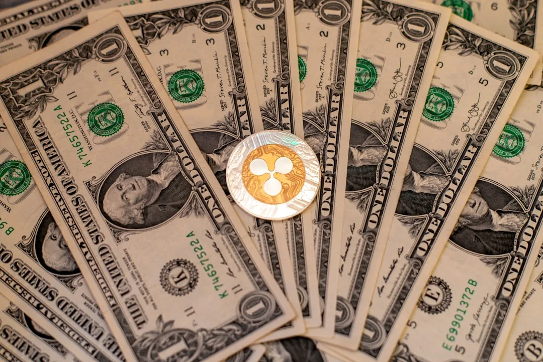 달러 지폐 위에 놓인 리플(XRP) 코인 — 결제용 코인 XRP를 상징하는 이미지